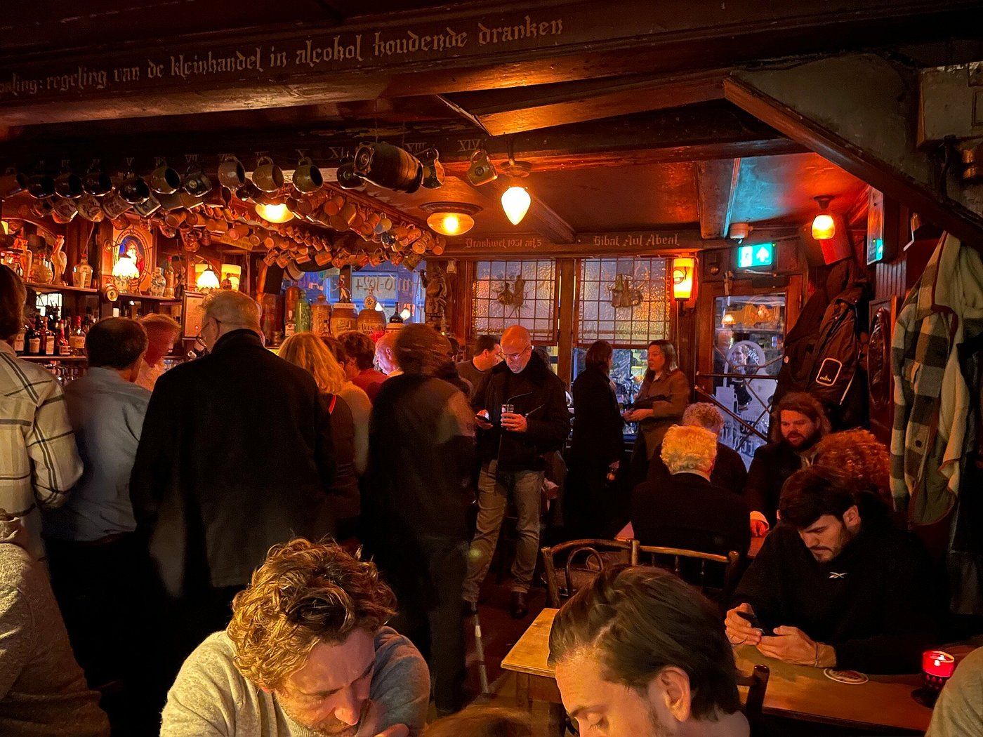 Drukbezocht Café Chris met gasten aan de bar
